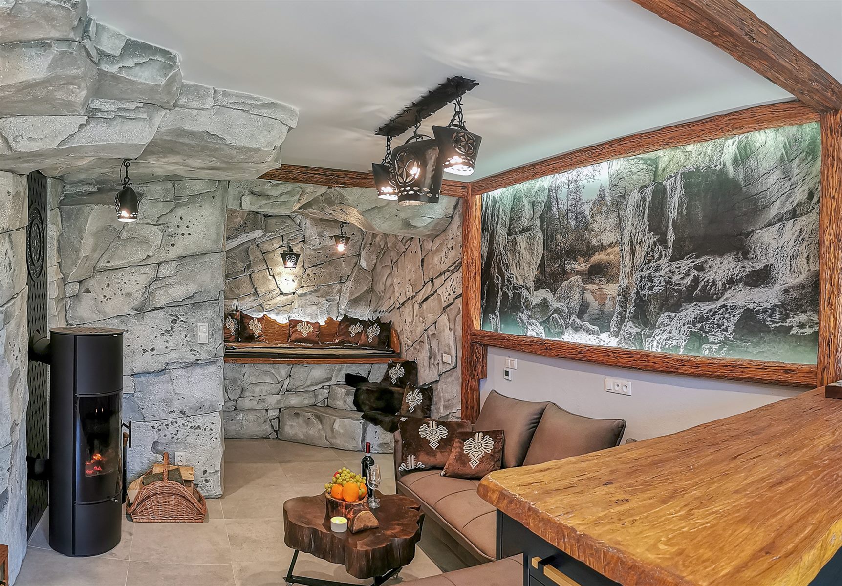 Wyjątkowy salon w apartamencie Pienińska Grota z wnętrzem stylizowanym na skalną jaskinię, nowoczesnym kominkiem i dużą grafiką przedstawiającą wąwóz