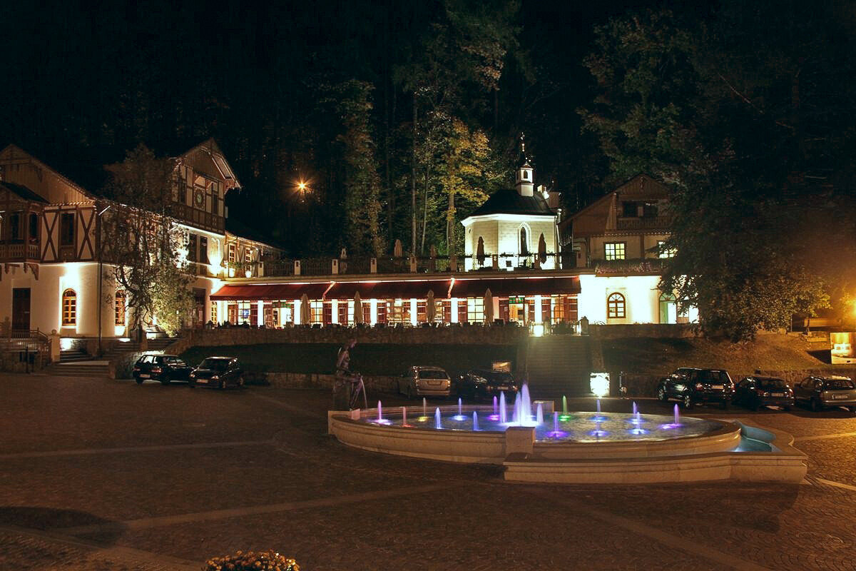 Nocny widok na zrewitalizowany Plac Dietla w centrum uzdrowiska Szczawnica z podświetlaną fontanną i zabytkową architekturą