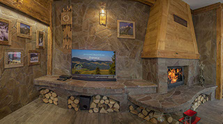 Salon w apartamencie z kominkiem, w stylu góralskim. Apartament w Jaworkach